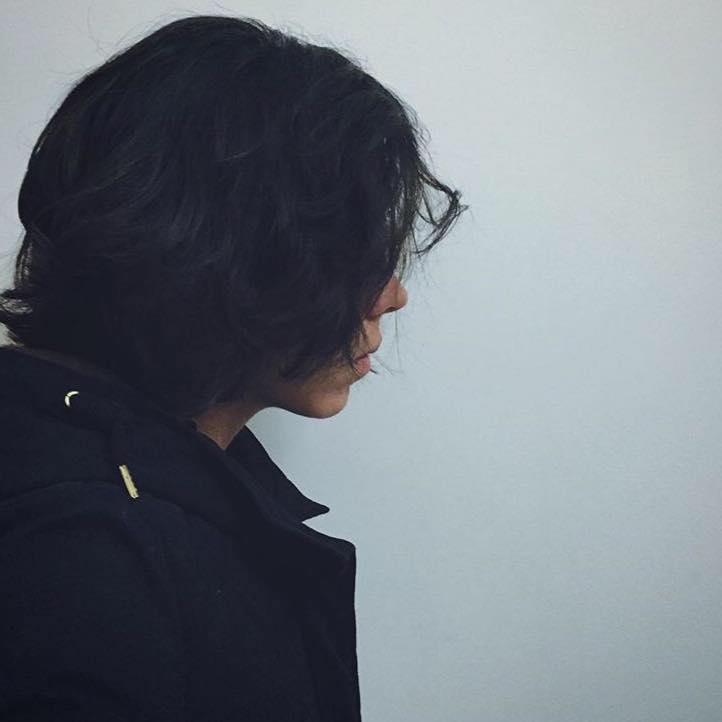 Game designer working on a laptop with game development software visible on screen in dark room with RGB lighting